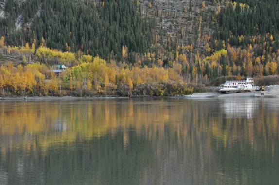 Uma balsa faz a travessia de veículos através do rio Yukon, em Dawson City, no Canadá
